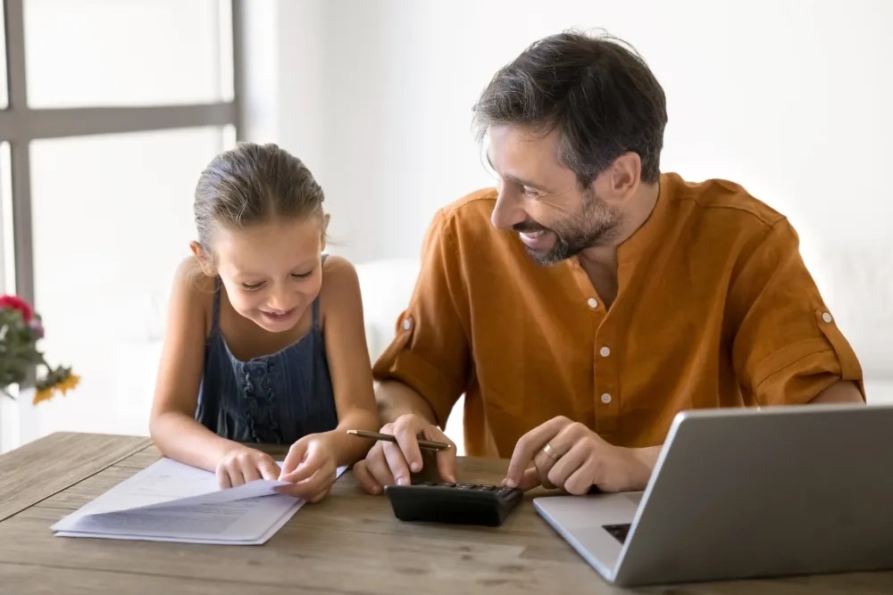 padre enseñando a hija dónde ahorrar el dinero