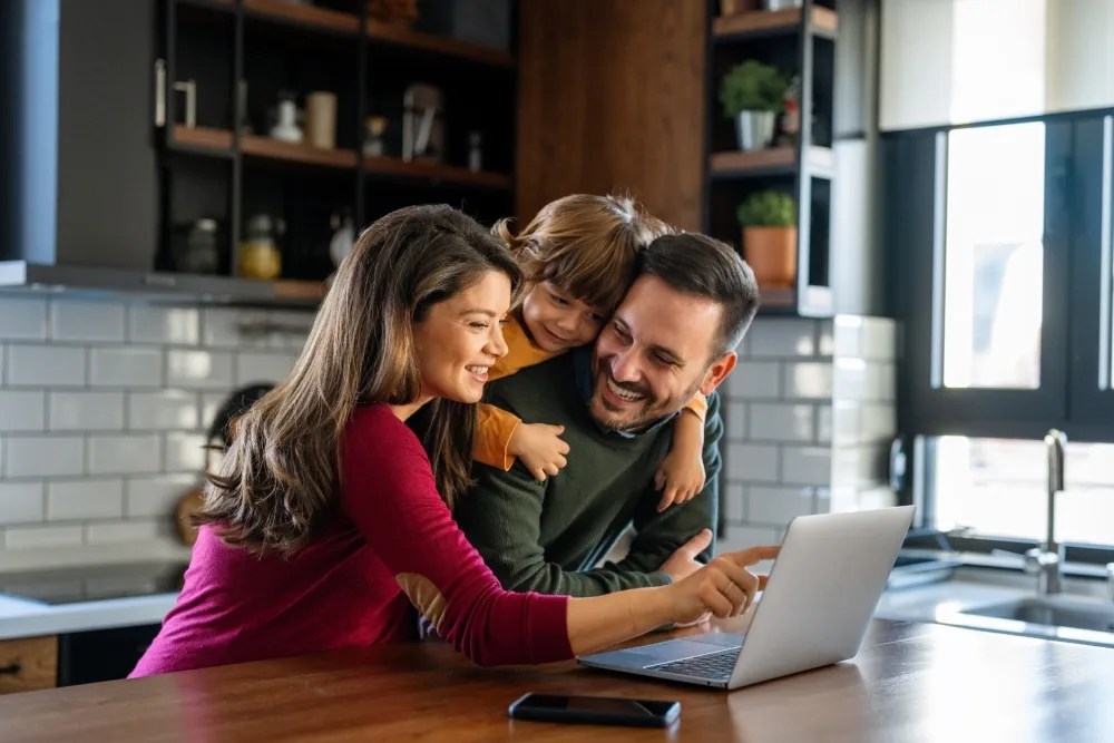 economía familiar: familia contenta revisando computador