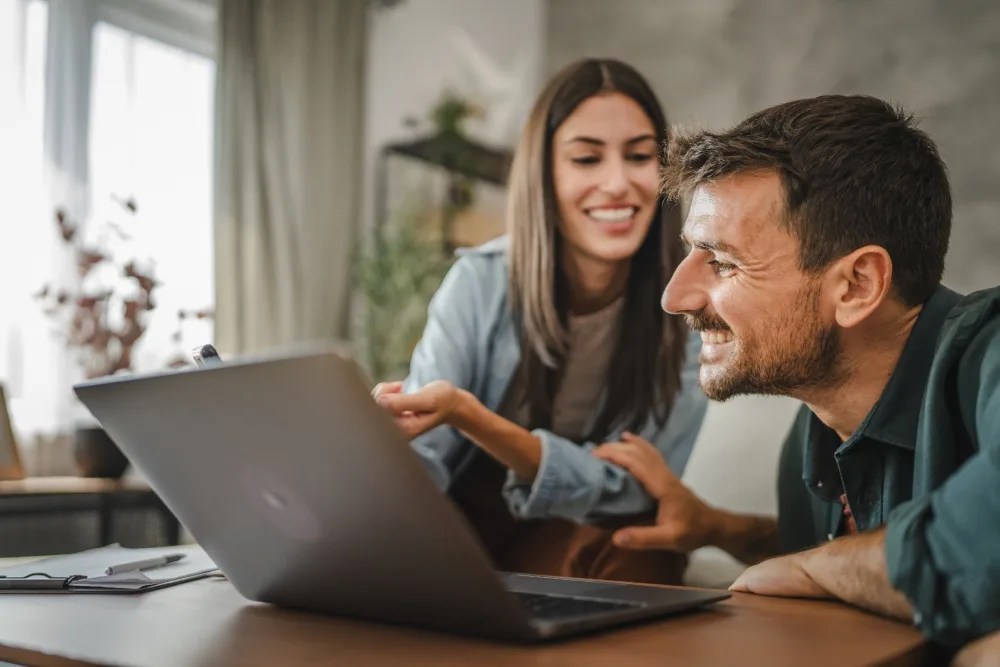 pareja revisando en computador su itinerario de viaje