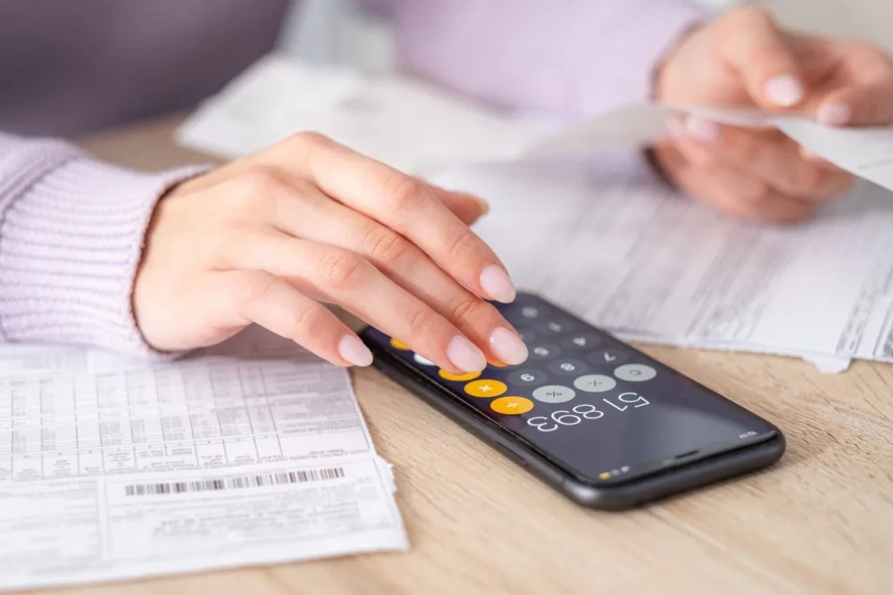 persona con calculadora revisando utilidades