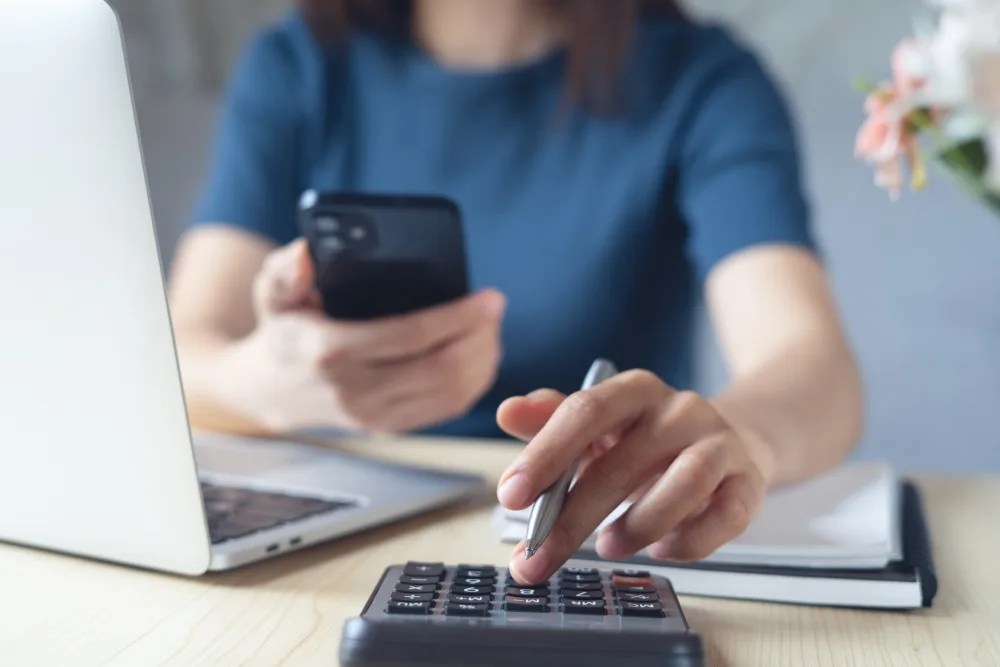 Mujer con calculadora revisando pago de utilidades