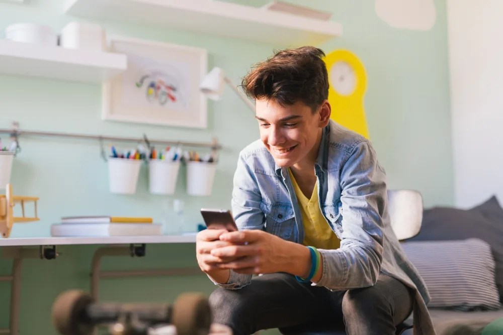 Adolescente buscando en celular consejos de finanzas