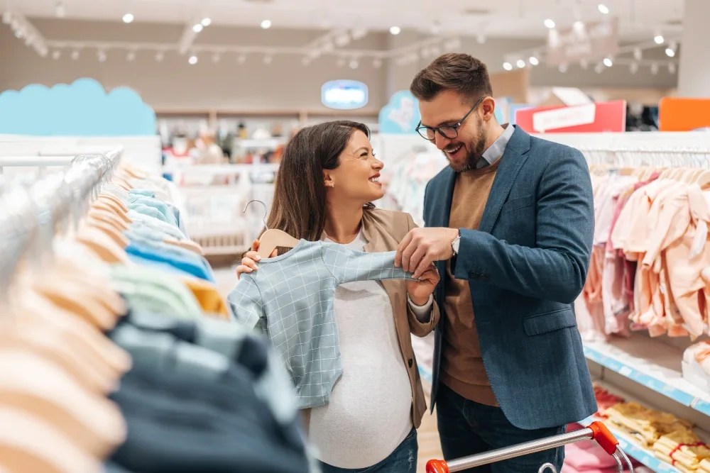 plan de ahorro: pareja comprando ropa al bebé
