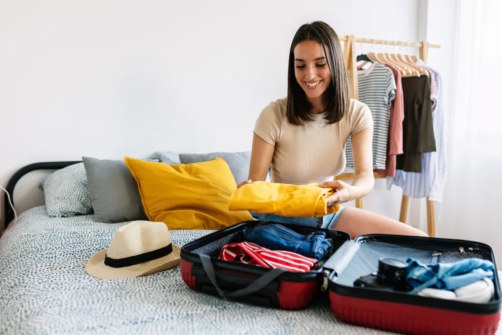 mujer empacando al conocer qué es la prima vacacional