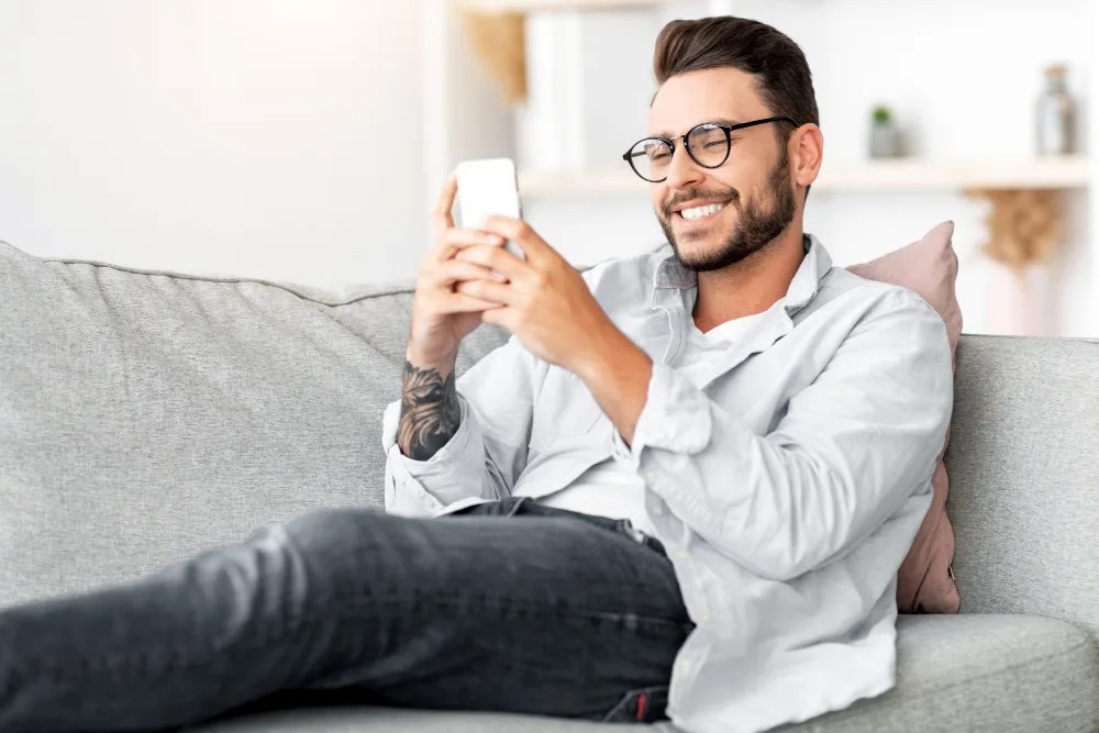 hombre revisando en celular los beneficios del ahorro voluntario