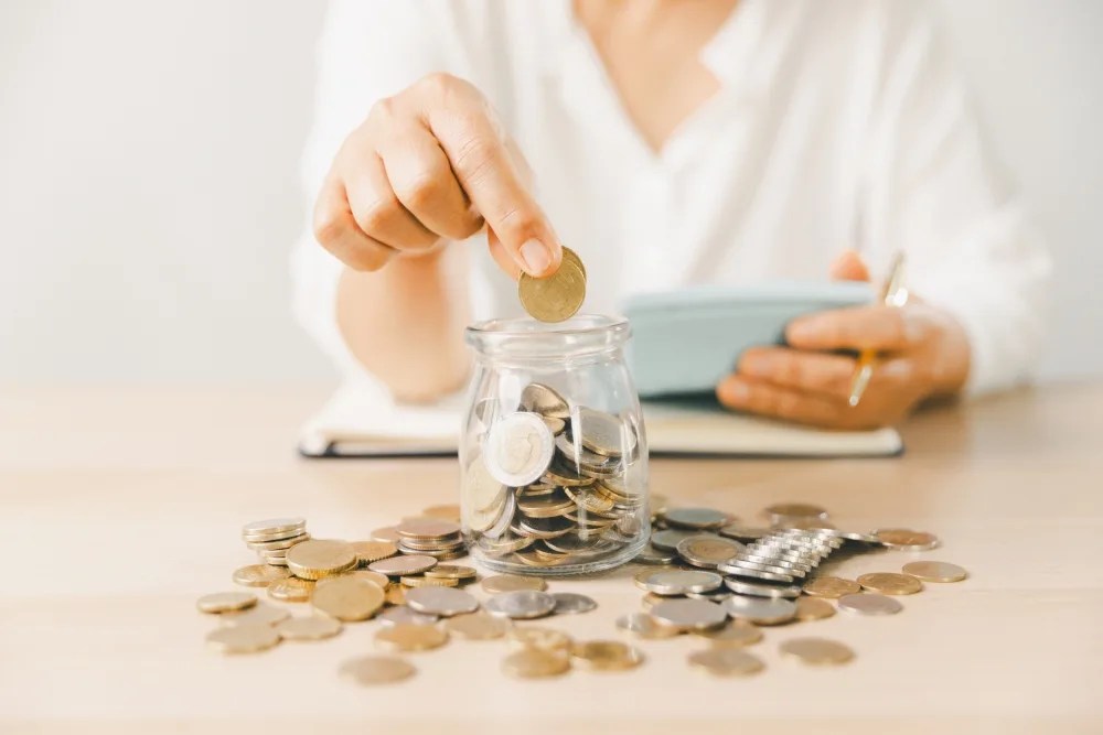 Mujer contando monedas desde su ahorro
