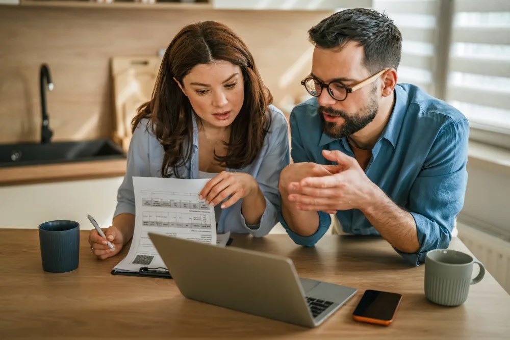 pareja revisando su presupuesto familiar preparandose para la cuesta de agosto
