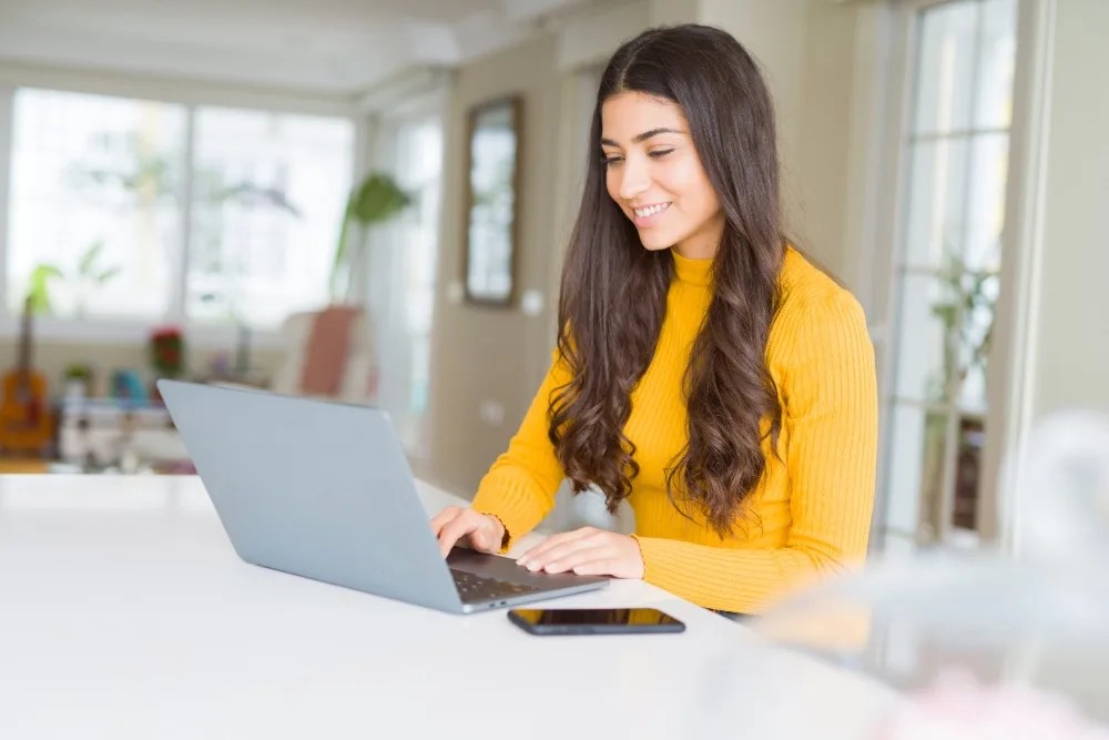 Mujer en su computadora revisando cómo funcionan los depósitos a plazo fijo