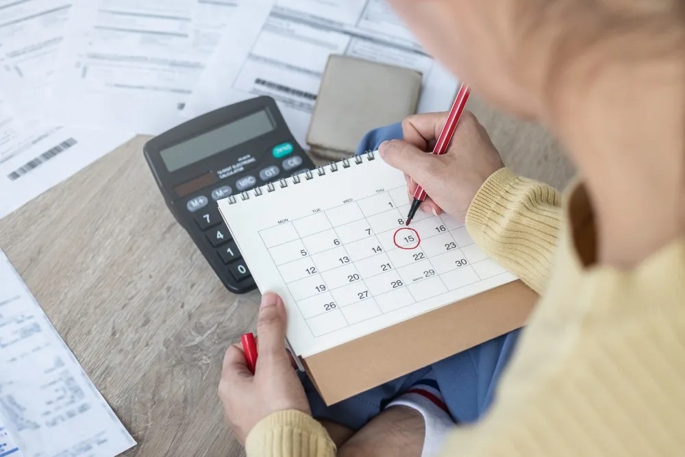 persona anotando en calendario sus pagos