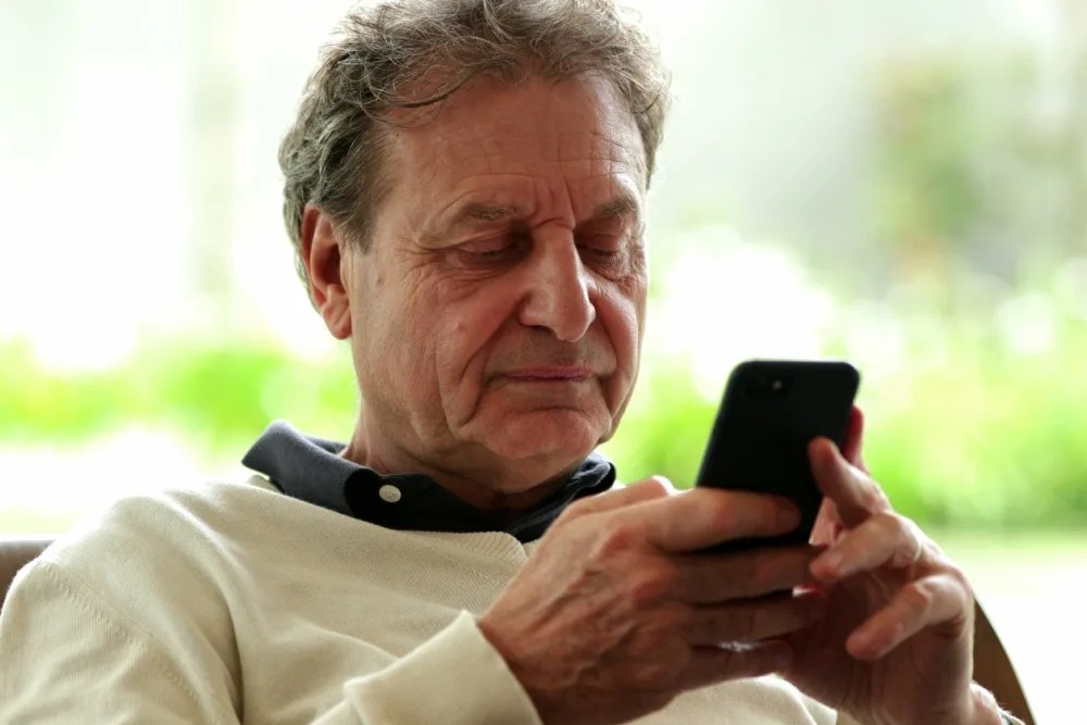 Adulto mayor utilizando la banca digital en su celular