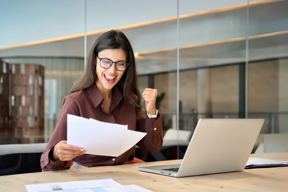Mujer contenta al ver que su comportamiento crediticio es saludable.