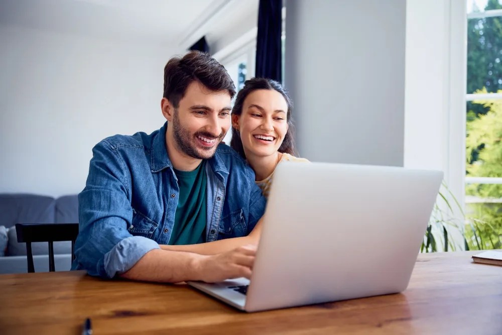 Pareja revisando en su computadora qué revisan los bancos para aprobar un crédito hipotecario