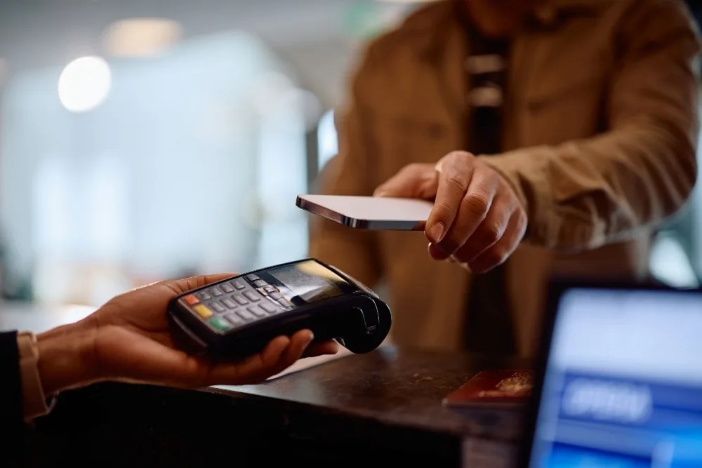 persona pagando con su celular luego de revisar su app para control de gastos